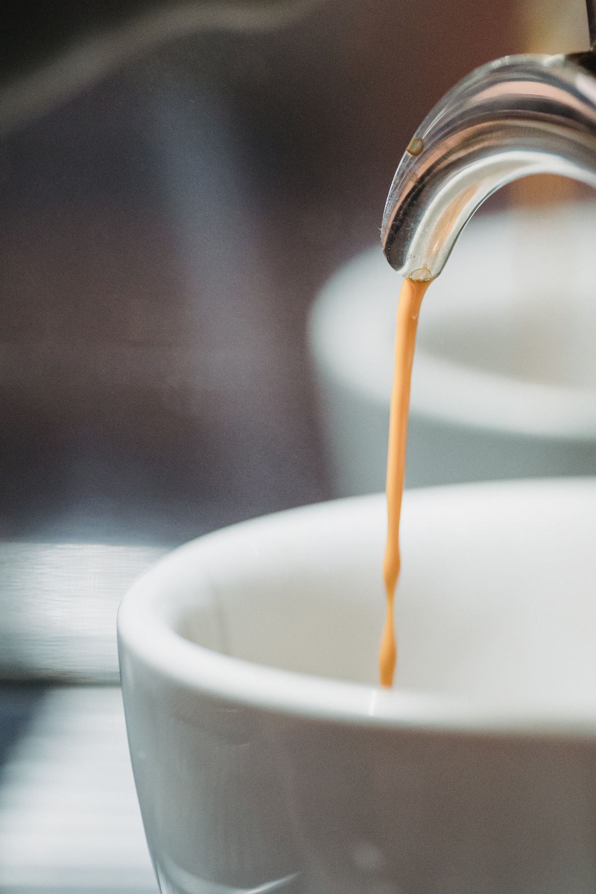 Espresso falling into a warmed cup
